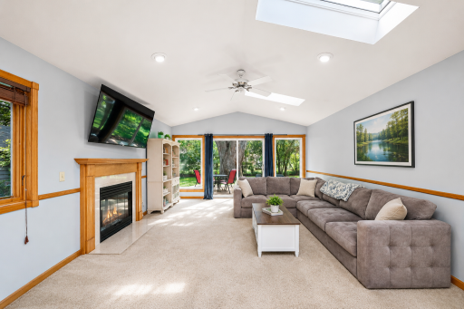 A favorite room in the home — vaulted ceilings, skylights, a cozy fireplace and walls of windows create a bright, inviting space overlooking the backyard.