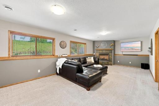 Lower level entertainment area ready for a cozy night by the fireplace