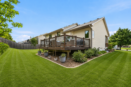 Beautifully landscaped backyard nestled along a mature tree line
