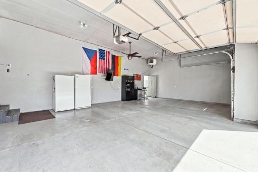 Heated three-car garage featuring a finished floor with plenty of room for storage