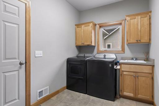 Main floor laundry with storage and sink