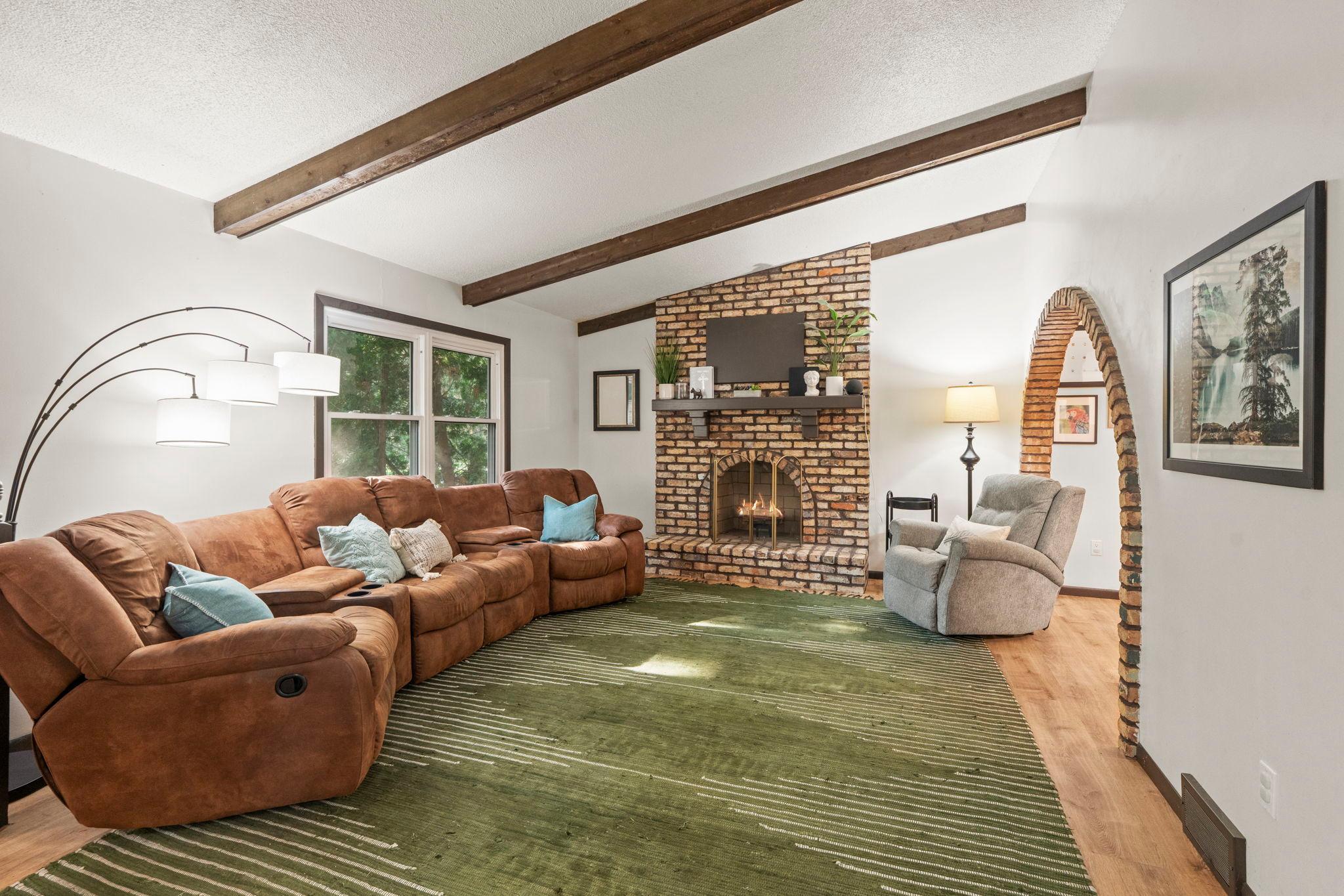 Spacious living room with beamed ceiling and decorative fireplace