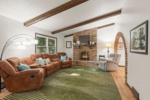 Spacious living room with beamed ceiling and decorative fireplace