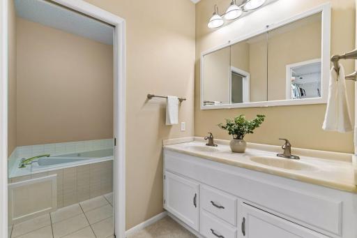 Private primary bath with dual sinks and separate jetted tub.