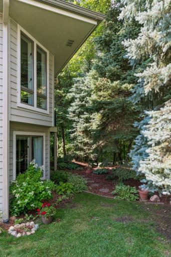 Walkout one-story design tucked into a lush, wooded backdrop.