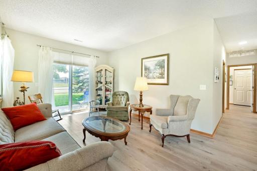 Open living room with LVP flooring has more than enough space for sofa, chairs, tables and an entertainment unit if desired.