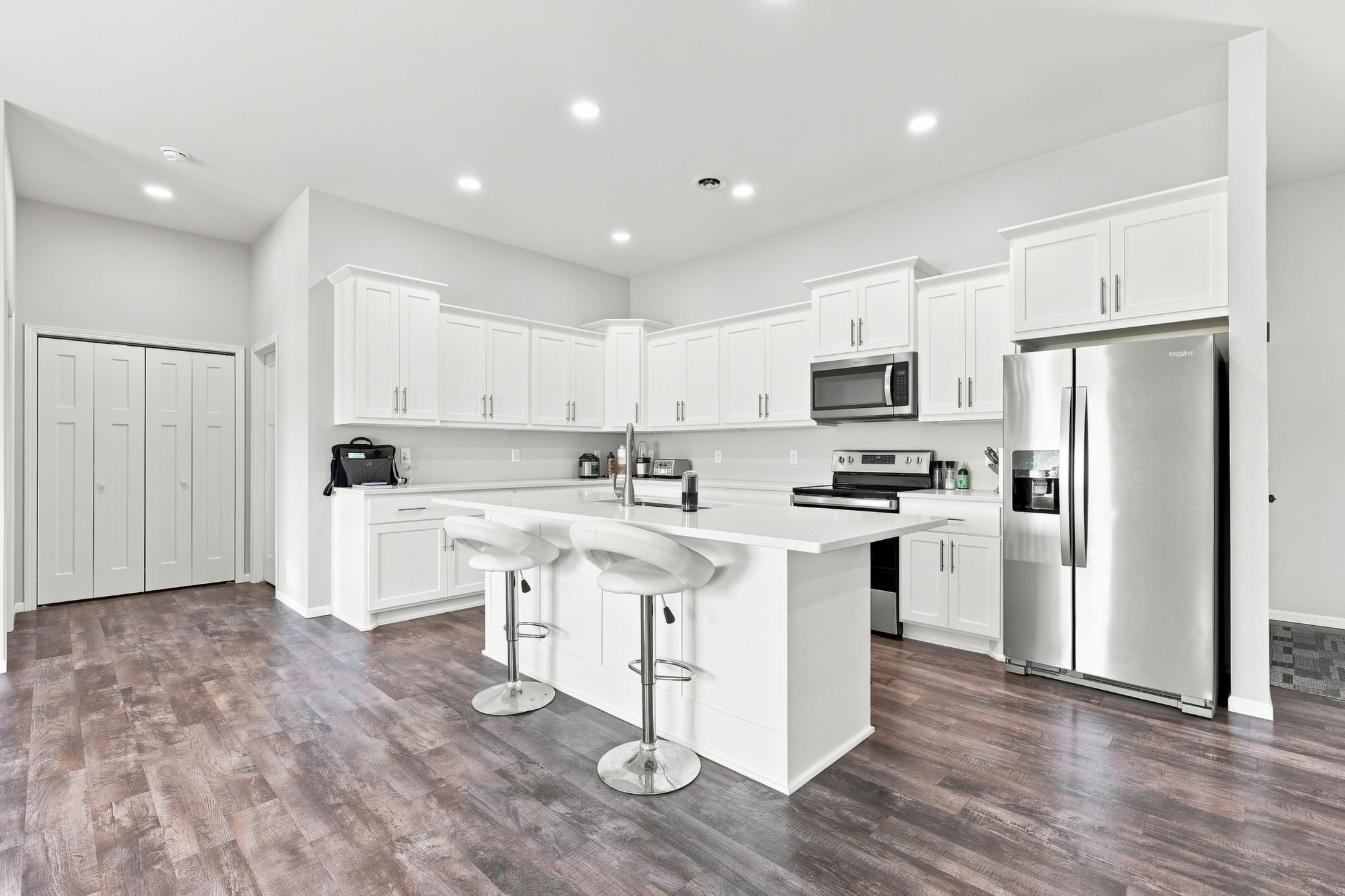 Kitchen with large island, ss appliances, quartz countertops (NOTE: Pantry off to side of kitchen)