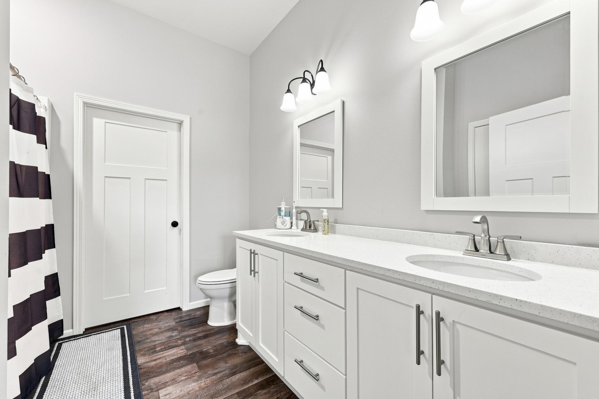 Master Bath (Full) with dual vanity, quartz countertops and entrance to walk-in closet.
