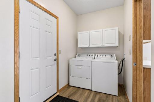 Convenient main-floor laundry room with overhead cabinetry, acting as a functional mudroom buffer just off the garage entrance.
