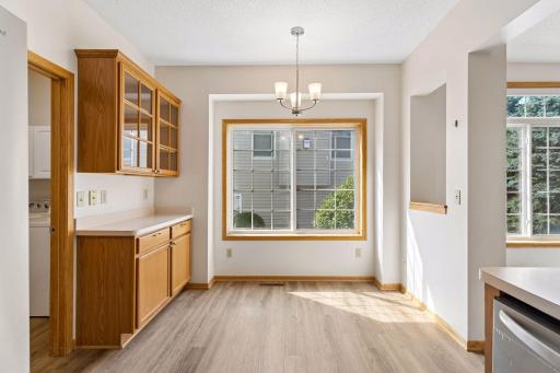 Sunny dining nook complete with a large window and custom built-in cabinetry with glass-door display storage.