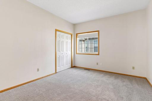 Generously sized main-level second bedroom (13'6" x 11'1") with large double-door closet storage, ideal for guests or a dedicated home office.