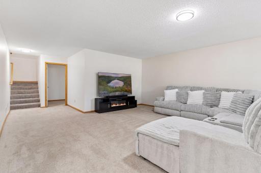 Comfortable basement entertainment area offering generous space for full-sized media setups and direct access to the lower-level bedroom and bath.