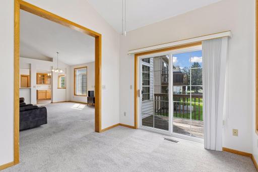 Open sunroom layout connecting seamlessly to the vaulted living room, offering an airy floor plan and tranquil outdoor views.
