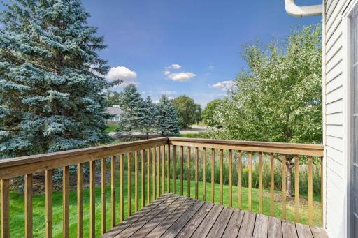 Private outdoor deck overlooking peaceful pond views, mature trees, and surrounding green space.
