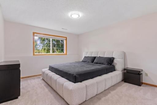 Spacious lower-level third bedroom (11'9" x 8'11") complete with a large lookout window that brings in abundant natural light.
