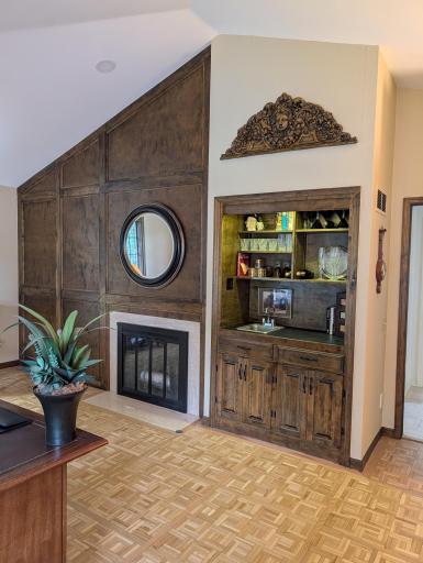 vaulted ceiling main level office/den with wood burning fireplace and wet bar