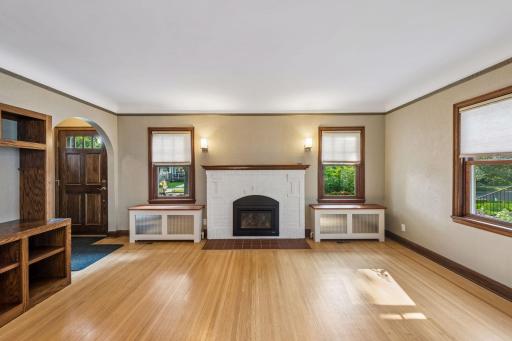 Another view of living room fireplace with wood mantel and sconce lighting. Nice built-in radiator covers.