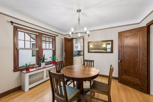 Dining room also features built-in radiator cover, thermal pane windows, original hardwood flooring, natural woodwork and coved ceilings.