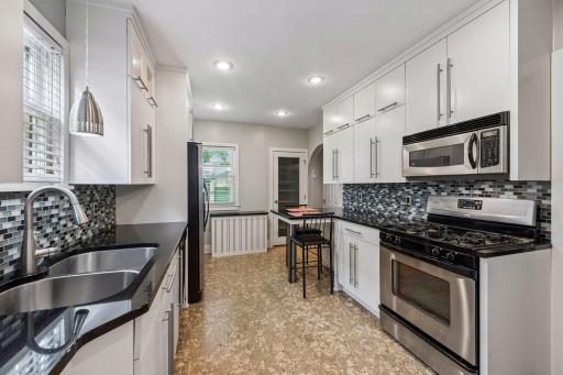 The kitchen has been updated with newer cabinets with lighting, granite c-tops, SS appliances, tiled backsplash, breakfast bar and walk-in Pantry!