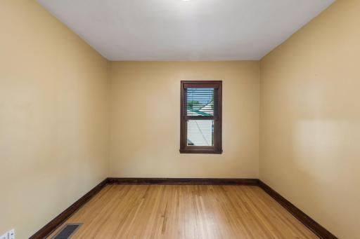Main floor rear bedroom features newer thermal pane windows, original hardwood flooring and natural woodwork.