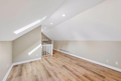 View of primary back to staircase, features baseboard heating with split wall a/c unit.