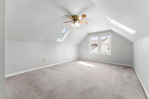 Spacious upper-level primary with skylights and abundant natural light.