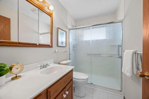 The nearby full bathroom has a walk-in shower, tiled floor, fresh paint (2026), and additional hall storage.