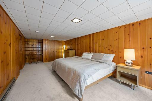 The newly added egress window (2026), wood-paneled walls, carpeting, and built-in desk and shelving give the room plenty of character and function.