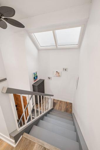 Large overhead skylights brighten the stairwell and create an open, airy transition between the home's two levels.