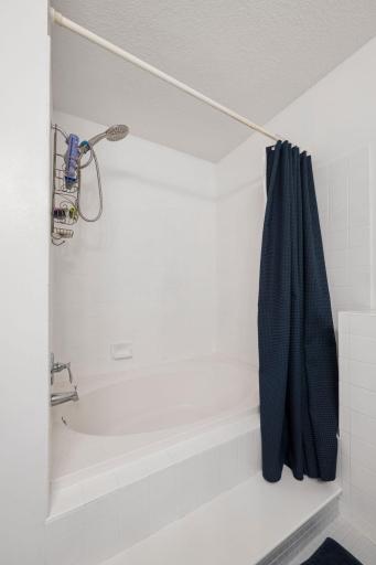 Full-size tub and shower combination located in the upper-level bathroom.