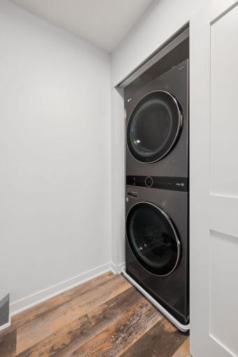 Convenient upper-level laundry closet with stacked washer and dryer located near both bedrooms.