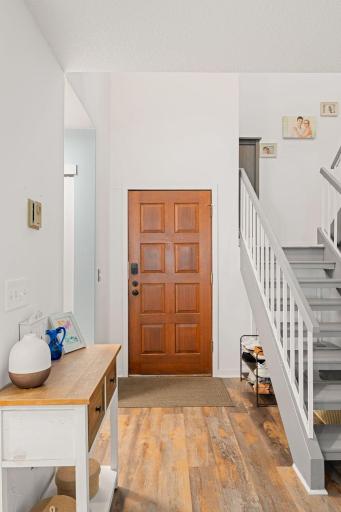 Welcoming front entry with warm flooring and convenient access to both the main living area and staircase to the upper level.