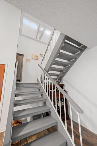 Open staircase connects the main and upper levels, with overhead skylights bringing additional natural light into the center of the home.