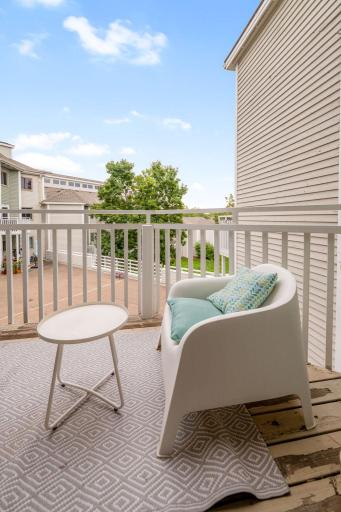 Private balcony offers a comfortable outdoor seating area and elevated views of the condominium community.
