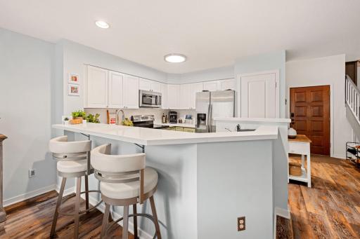 Functional kitchen design featuring wraparound counters and breakfast-bar seating for casual dining.