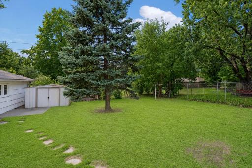 Large fenced-in backyard with storage shed.