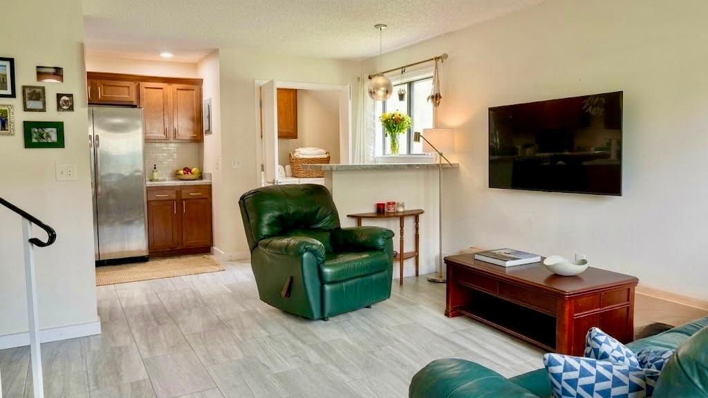 Comfortable living area with plush seating, a large flat-screen TV, and natural light pouring in a true relaxation zone.