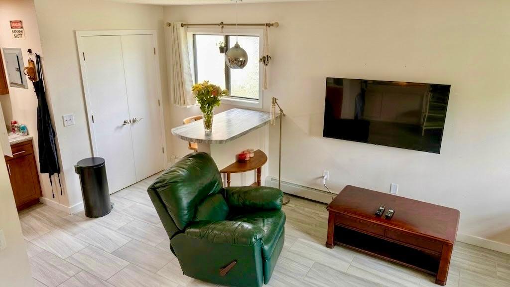 Another angle of the living space showcasing the open layout and functional furniture arrangement more room than it looks.