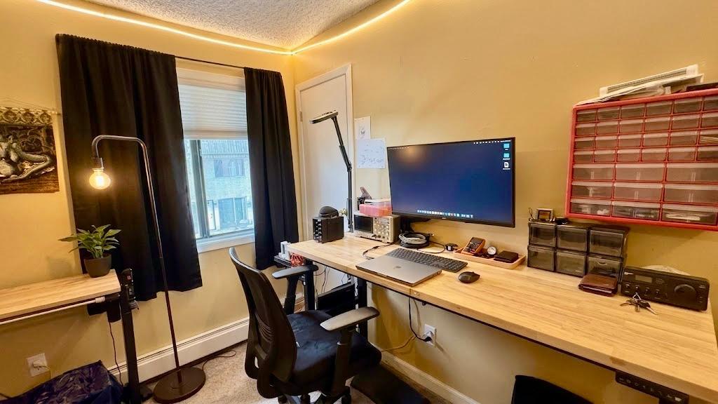 Well-lit office setup with a large desk and monitor space productive, professional, and right at home.