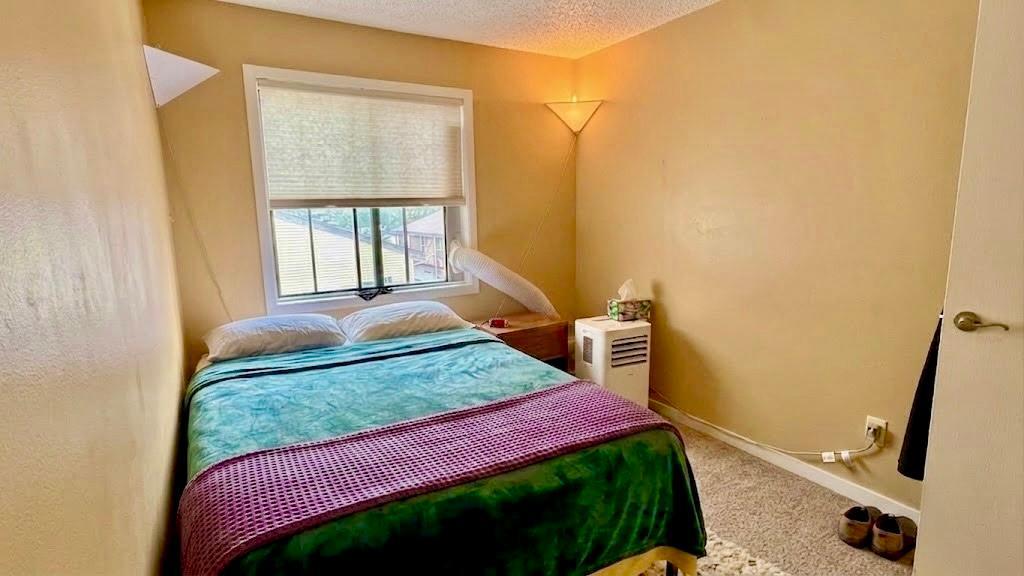 Spacious primary bedroom with a large window, neutral tones, and room for a full furniture set restful and refined.