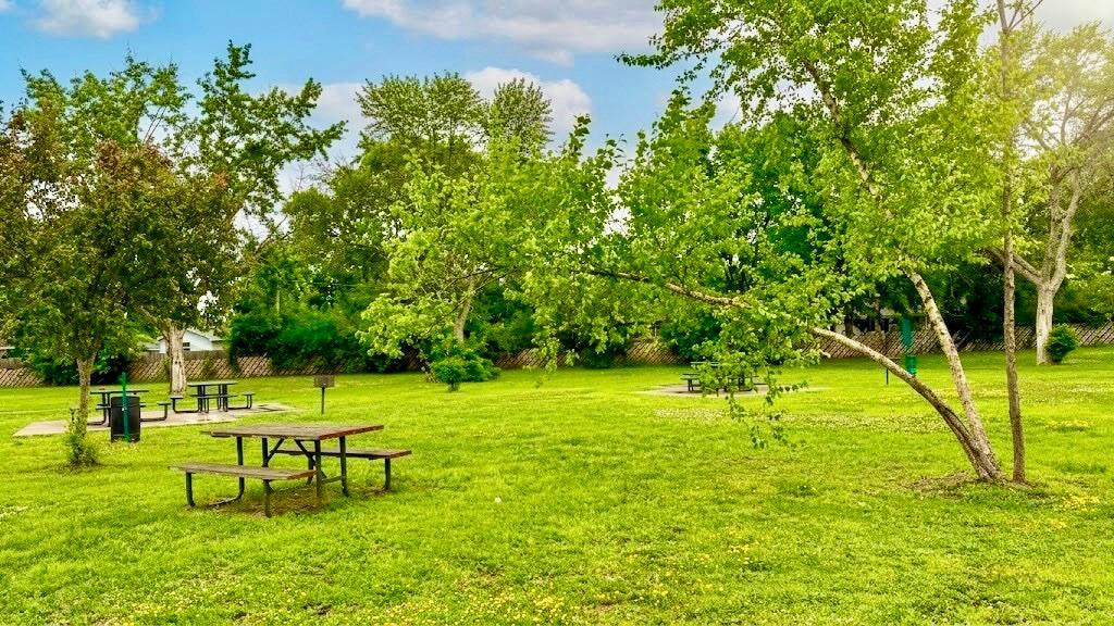 Picnic/Common Green Space Shaded common area with a picnic table nestled among mature trees perfect for casual gatherings or a quiet afternoon outside.