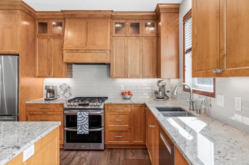 New cabinetry, countertops, stainless steel appliances, ceramic tile backsplash and a large custom center island with breakfast bar seating.