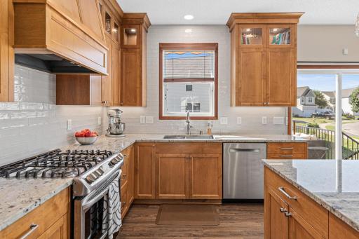 New cabinetry, countertops, stainless steel appliances, ceramic tile backsplash and a large custom center island with breakfast bar seating.
