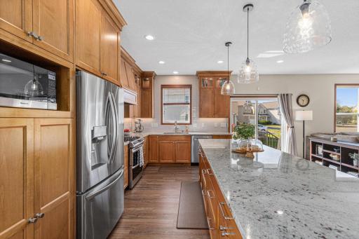 New cabinetry, countertops, stainless steel appliances, ceramic tile backsplash and a large custom center island with breakfast bar seating.