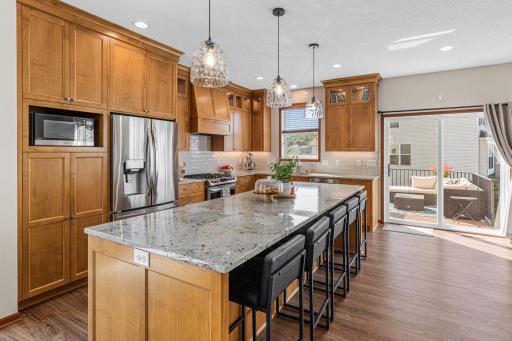 New cabinetry, countertops, stainless steel appliances, ceramic tile backsplash and a large custom center island with breakfast bar seating.