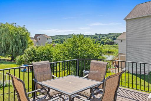 Step outside from the dining area to the large deck overlooking the pond and surrounding green space