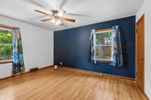 One of two spacious main floor bedrooms! Hardwood flooring, ceiling fan, and freshly painted walls!