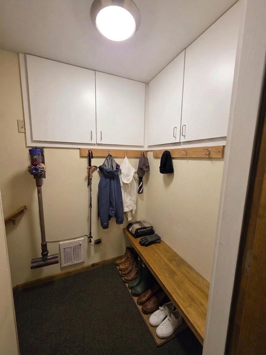 Highly functional mudroom with extensive custom cabinetry, built-in bench seating, hooks, and convenient shoe storage.