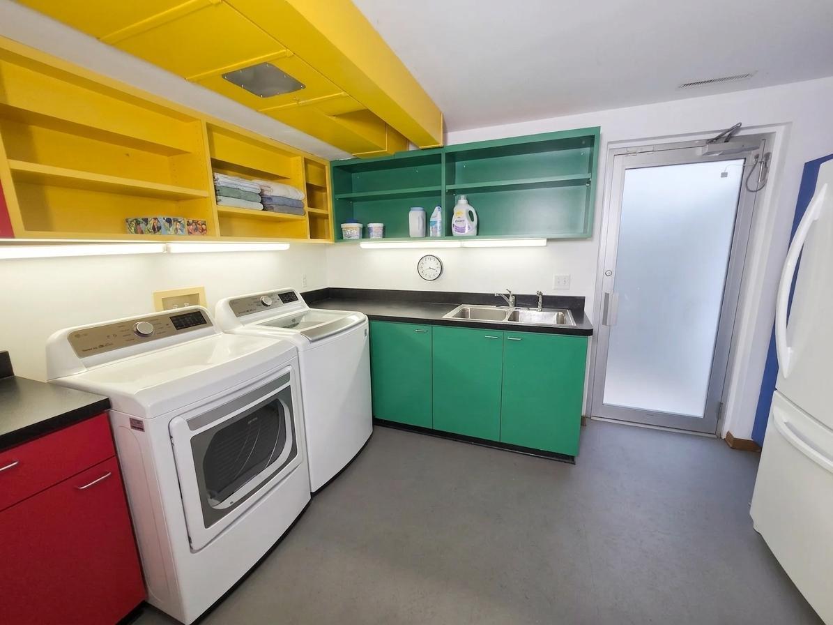 Exceptional laundry and utility room with abundant custom cabinetry, utility sink, generous counter space, and full-size appliances.