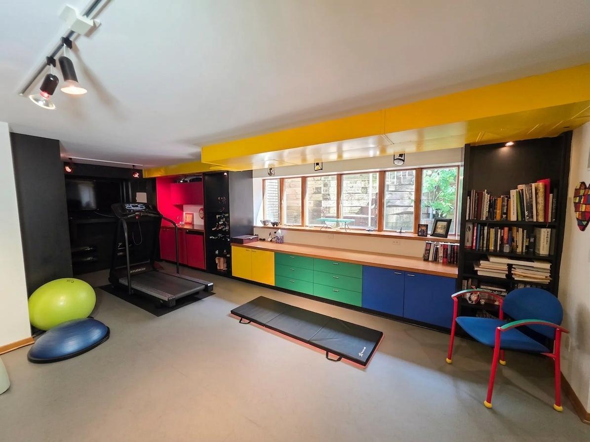 Expansive recreation and fitness space featuring wall-to-wall custom cabinetry, abundant natural light, and room for multiple activities.